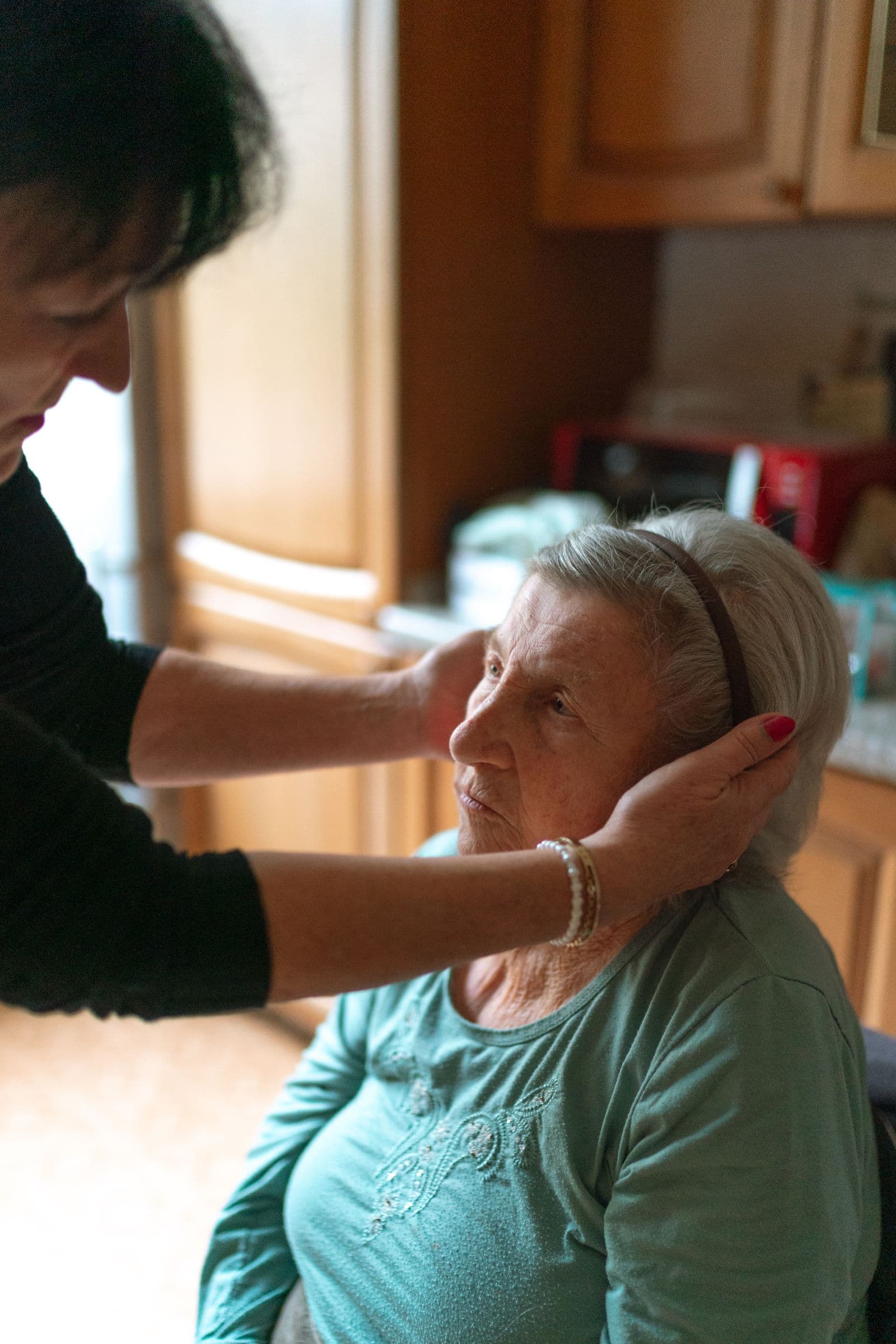 Caregiver gently helping an elderly client at home